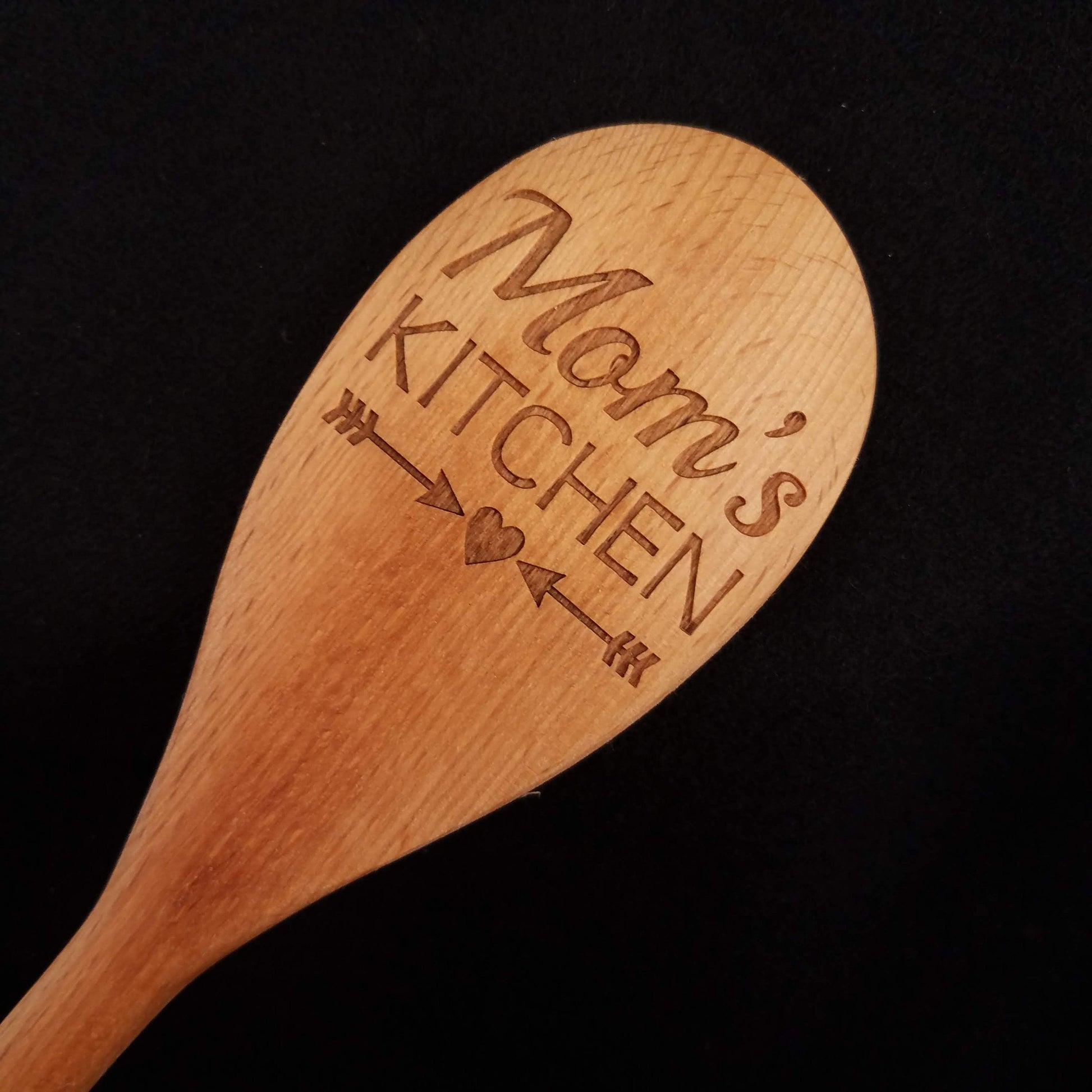 Customizable beech wood spoon laser engraved with Mom's Kitchen and a heart and arrow design