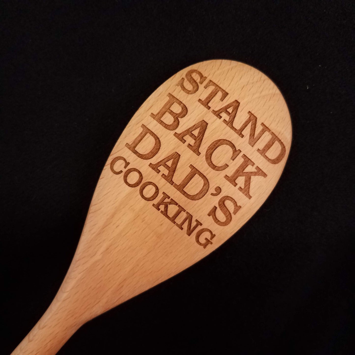 Customizable beech wood spoon laser engraved with Stand Back Dad's Cooking